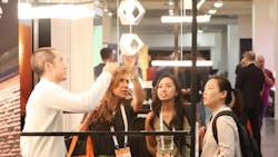 People looking at lighting fixture at LightSPEC West. People looking at lighting fixture at LightSPEC West.