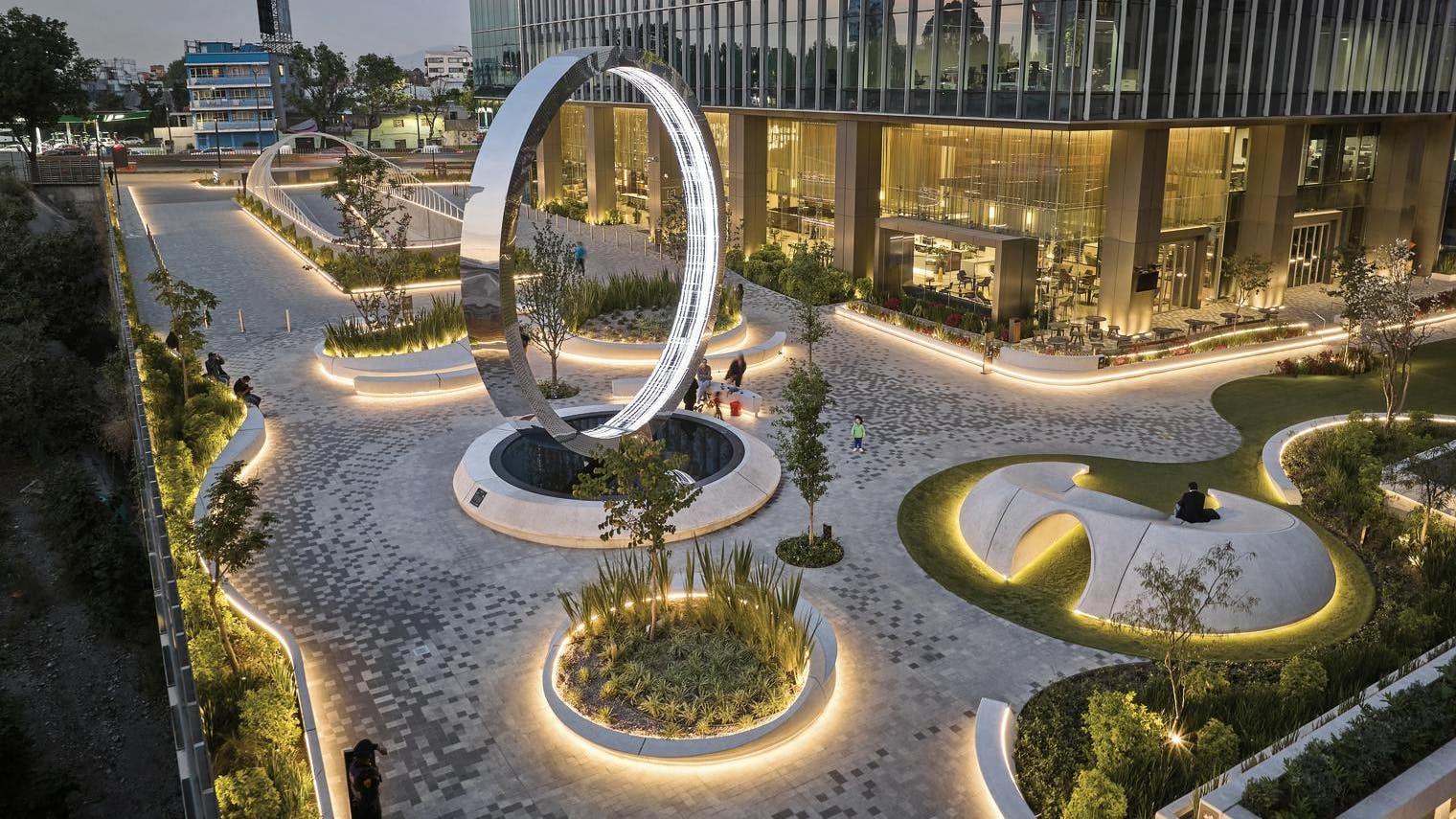The plaza at Corporativo Neuchatel in Mexico City, Mexico, designed by HOK, has a striking entrance where sculpted corners accentuate the tower's presence and integrate into the urban landscape. The Eye of Mexico, a large digital art sculpture designed by art collectives Ouchhh and MASSIVArt, provides a perfect social media moment.