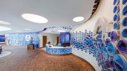 A curved mosaic feature wall is illuminated with LED PAR20 lamps in the children’s hospital lobby. A curved mosaic feature wall is illuminated with LED PAR20 lamps in the children’s hospital lobby.