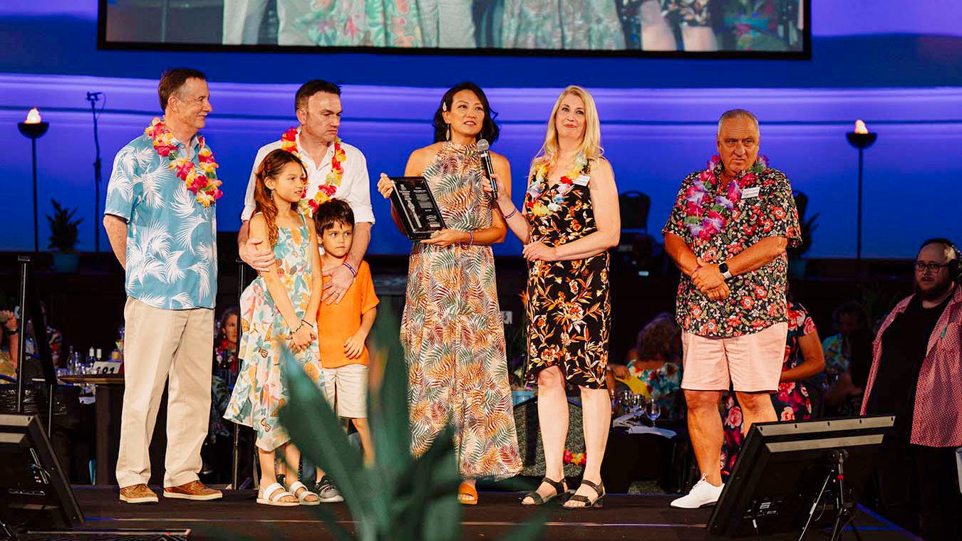 Dirk and Shelley Wald (back row, second and third from left), accept the 2023 Rick Wiedemer Guiding Light Award at The H Foundation's annual 2023 Goombay Bash fundraiser.