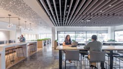 The company café features decorative pendant lighting from E. Kraemer over the bar tables and Tech Lighting over the booths. Track lighting is recessed within the ceiling baffles. The company café features decorative pendant lighting from E. Kraemer over the bar tables and Tech Lighting over the booths. Track lighting is recessed within the ceiling baffles.