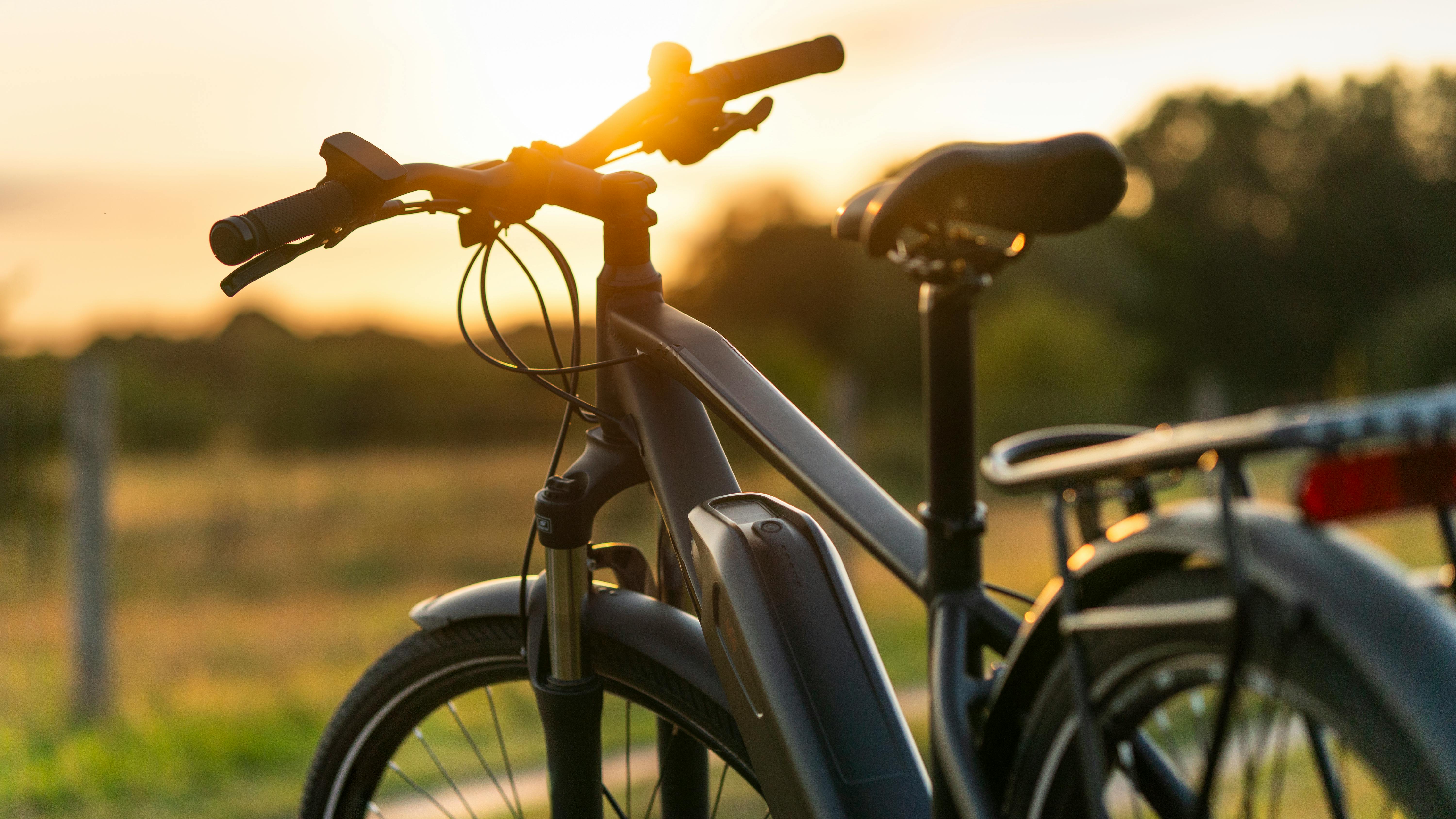 Close-up of e-Bike silhouetted against sunset in the background.