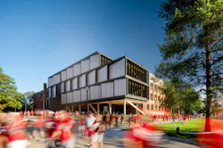 The mass timber and metal addition to the north facade of UNL's historic Architecture Hall was designed to be a material complement to the original red brick, hip-roofed, timber structure, visible here in the background.