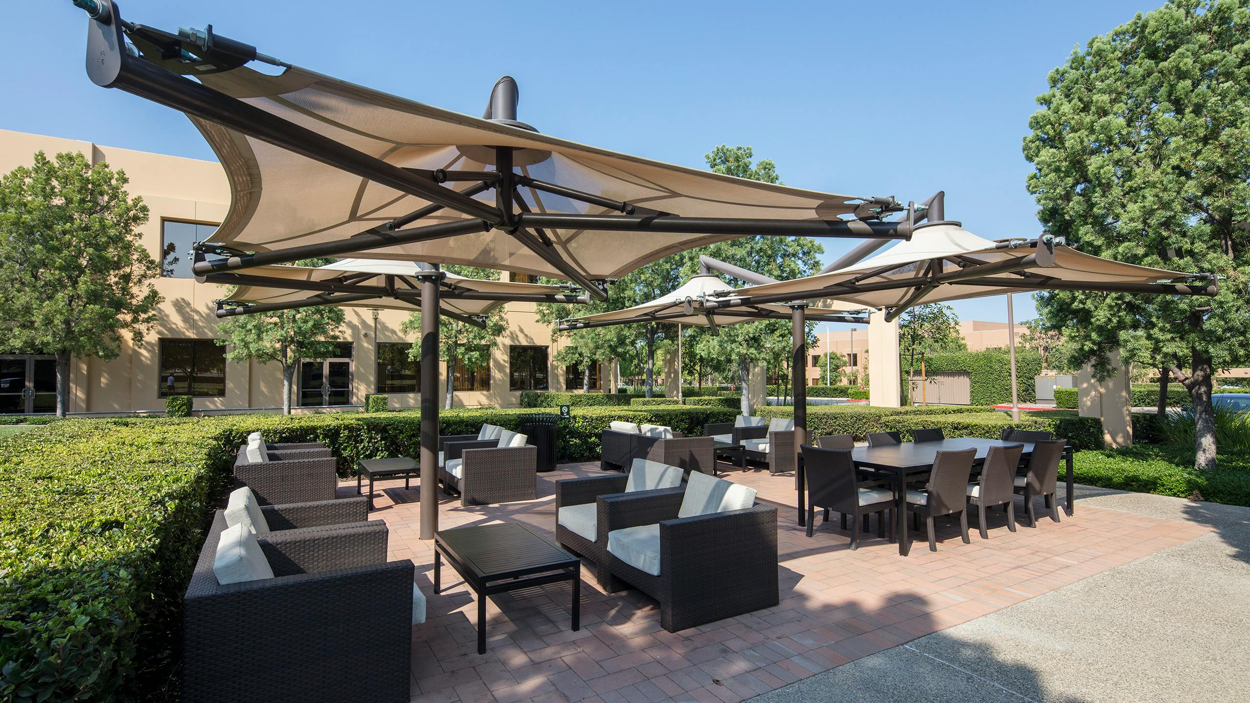 Outdoor business patio with tensile structure sunshades.