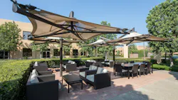 Outdoor business patio with tensile structure sunshades.