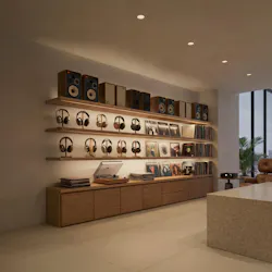 Shelves with headphones, speakers, record players, and lit with concealed linear luminaires.