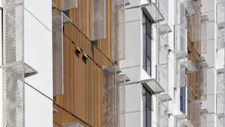 Building exterior with rust-look metal facade and bracketless solar shades.