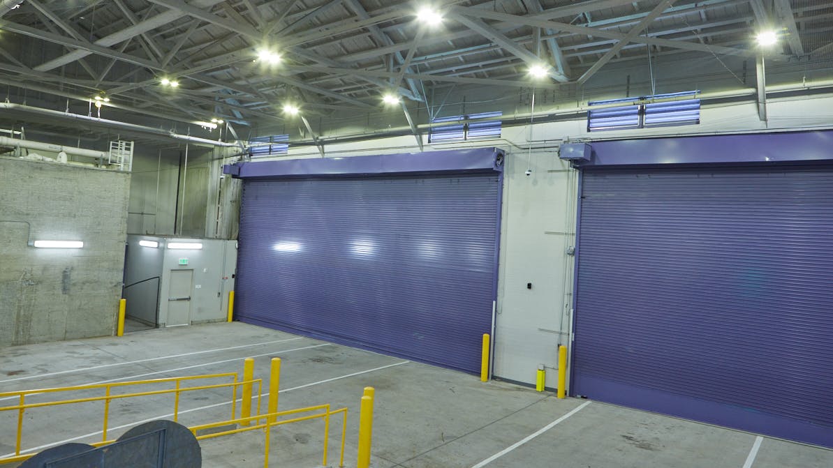 Two purple insulated rolling doors at the exterior loading dock of the San Francisco Flower Market.