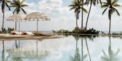Poolside scene with palm trees and Marbella sun loungers under umbrella.