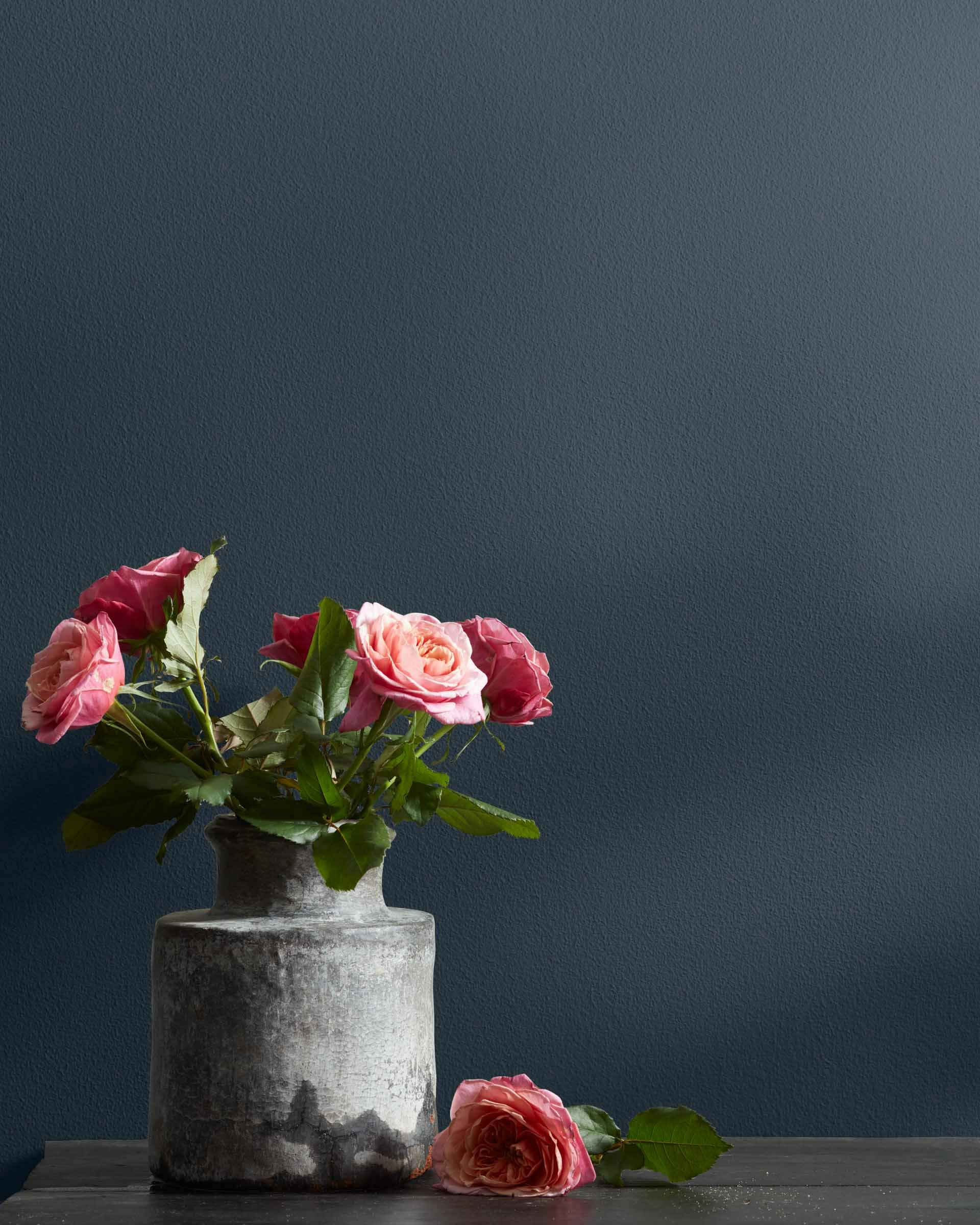 Blue Note paint with pink flowers on a table.