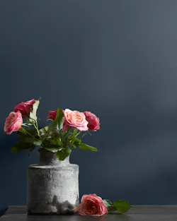 Blue Note paint with pink flowers on a table.