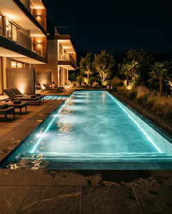 Nighttime image of pool illuminated by underwater luminaires.