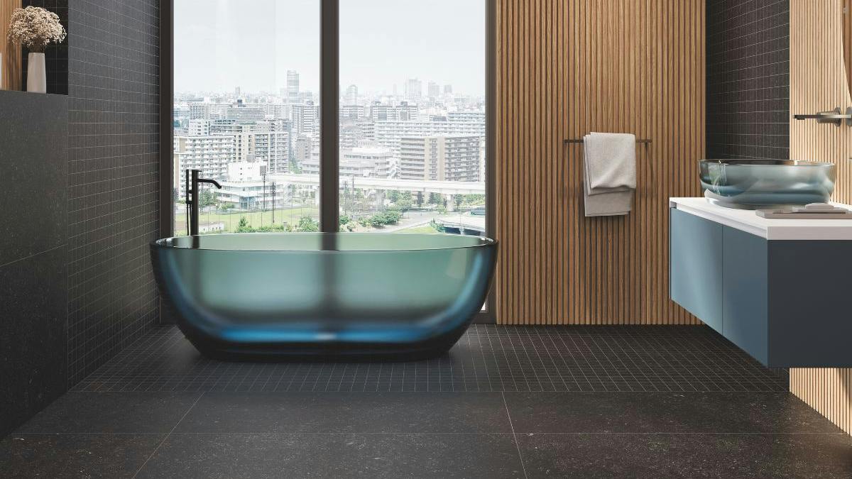 Black tile in bathroom with bathtub by the window.