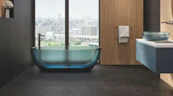 Black tile in bathroom with bathtub by the window.