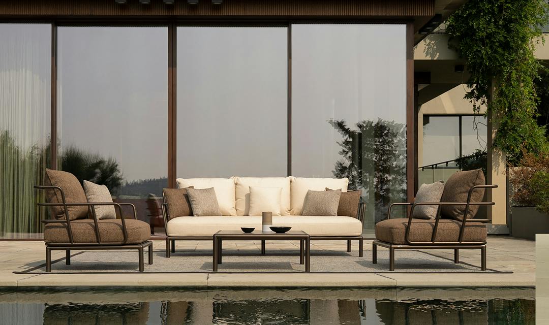 Sofa and two chairs placed poolside.