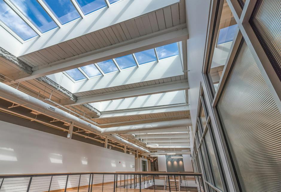 Modular metal-framed skylights in a roof offering access to daylight and fresh air.